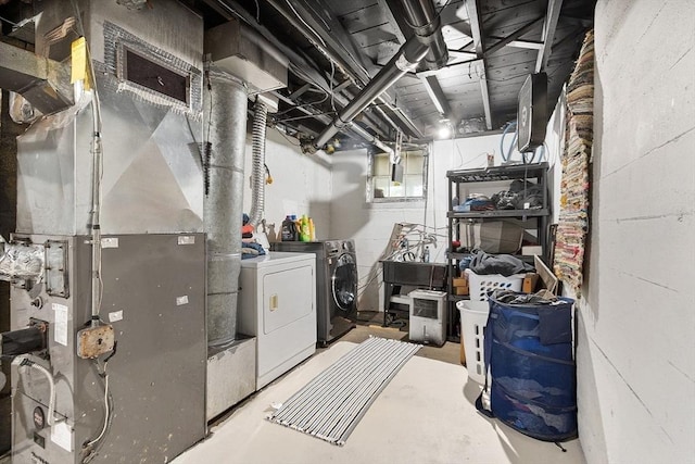 unfinished basement featuring washer and clothes dryer, heating unit, and concrete block wall