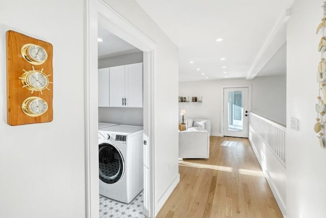 washroom with cabinets, washer / dryer, and light hardwood / wood-style floors