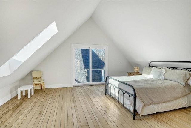 bedroom featuring light hardwood / wood-style flooring and vaulted ceiling with skylight