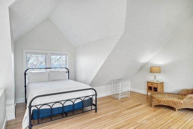 bedroom with light hardwood / wood-style floors and vaulted ceiling