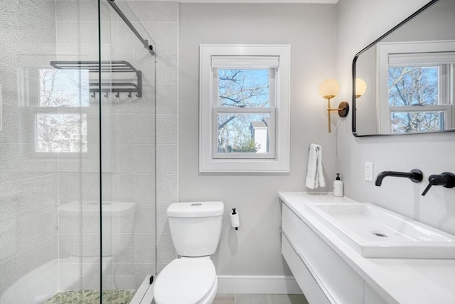 bathroom with tile patterned flooring, a shower with door, vanity, and toilet