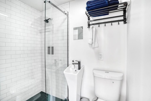 bathroom with tiled shower and toilet