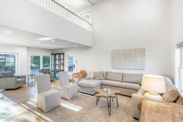 living room featuring light wood-type flooring and a high ceiling