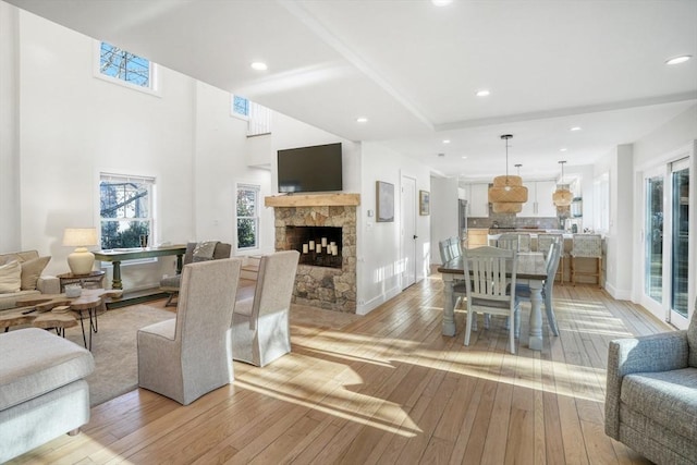 living room featuring a stone fireplace and light hardwood / wood-style floors