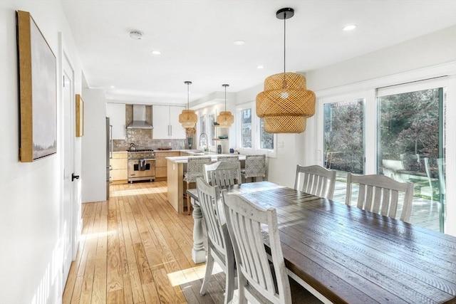 dining room featuring sink and light hardwood / wood-style floors