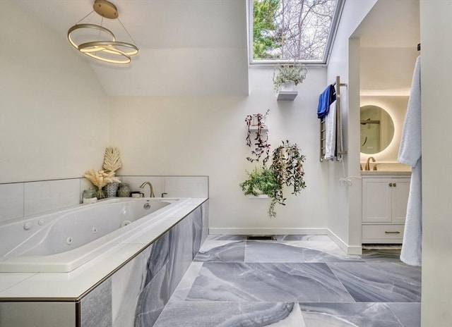 full bathroom featuring baseboards, marble finish floor, a whirlpool tub, and vanity