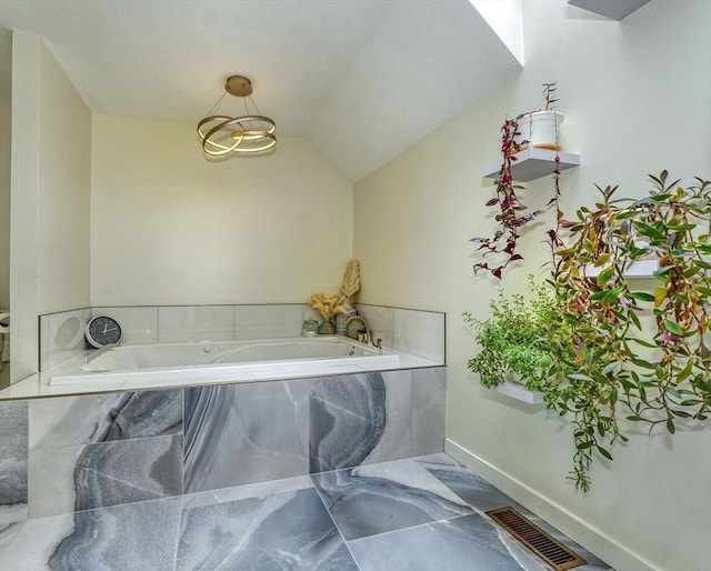 bathroom featuring lofted ceiling, a bath, and visible vents