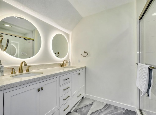 full bath featuring a shower with door, double vanity, baseboards, and a sink