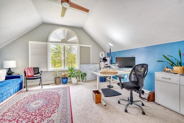 carpeted home office with a ceiling fan and vaulted ceiling