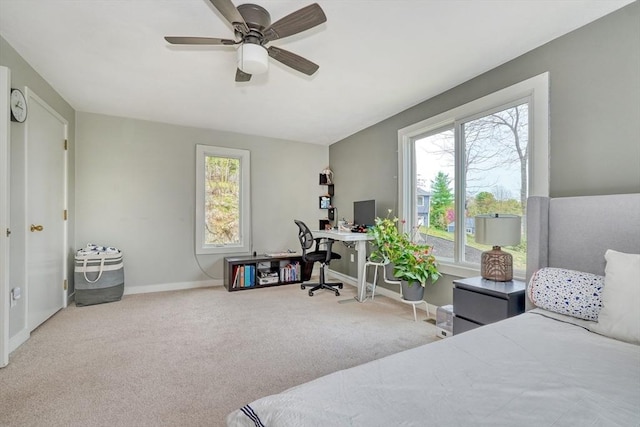 carpeted bedroom with baseboards, multiple windows, and a ceiling fan
