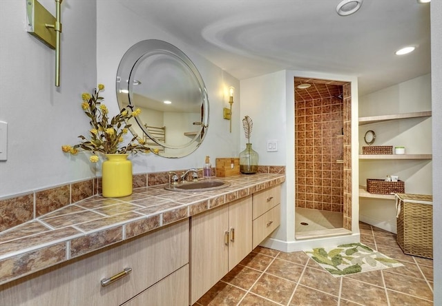 full bathroom with recessed lighting, a tile shower, tile patterned flooring, and vanity