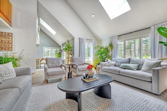 living area with a skylight, high vaulted ceiling, baseboards, recessed lighting, and light wood-style flooring