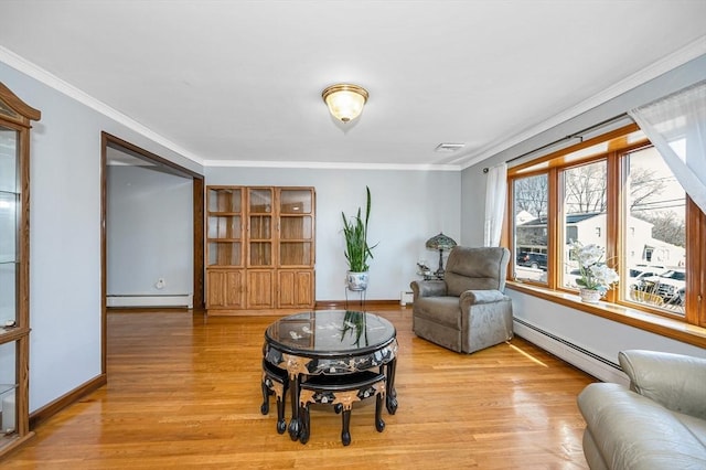 living area featuring a baseboard heating unit, crown molding, baseboards, and light wood-type flooring