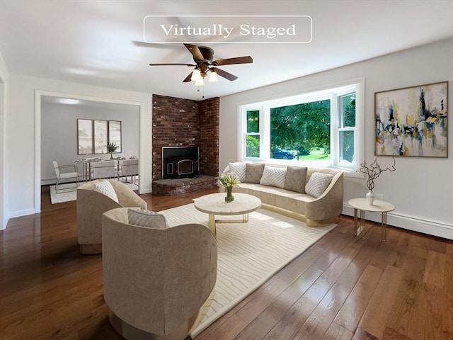 living room featuring dark hardwood / wood-style flooring, a wood stove, baseboard heating, and ceiling fan