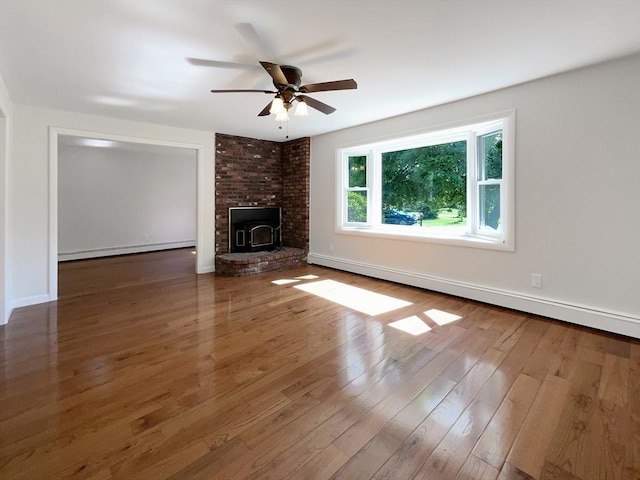 unfurnished living room featuring dark hardwood / wood-style flooring, a baseboard radiator, a wood stove, and ceiling fan