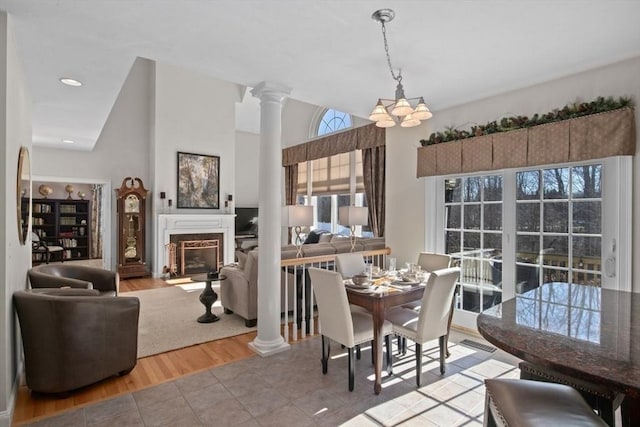 tiled dining space with decorative columns and vaulted ceiling