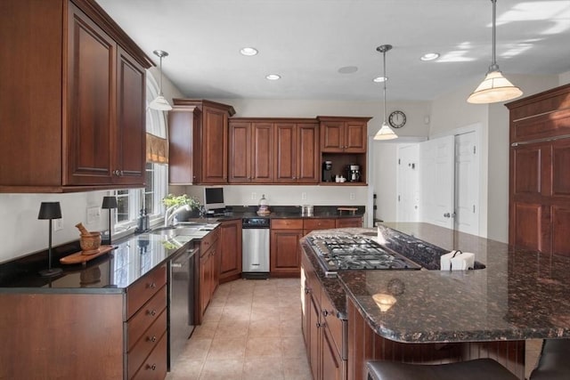 kitchen with a breakfast bar area, dark stone countertops, appliances with stainless steel finishes, pendant lighting, and a large island