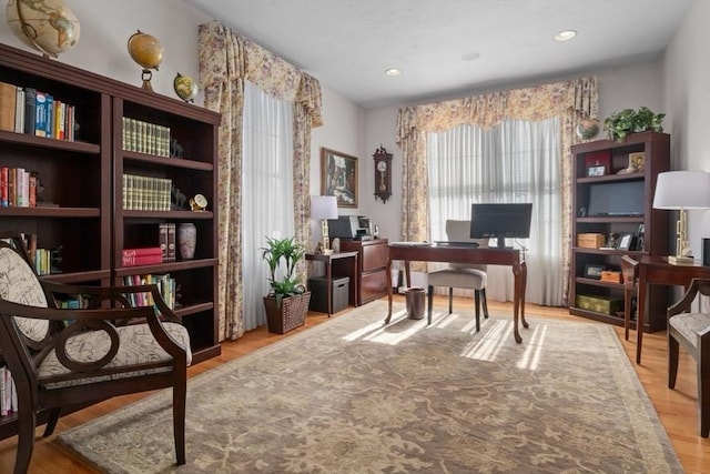 home office with light hardwood / wood-style flooring