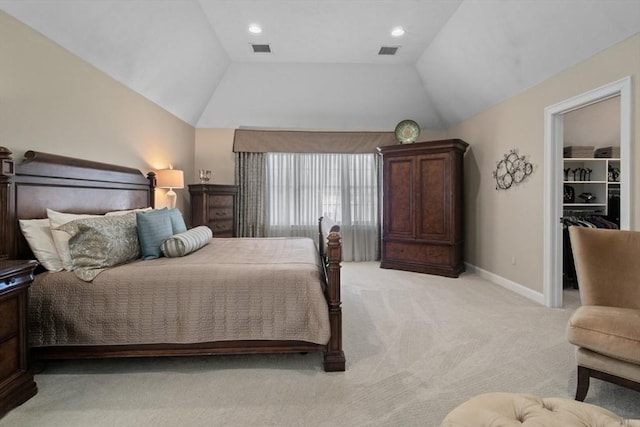 carpeted bedroom featuring a spacious closet and vaulted ceiling