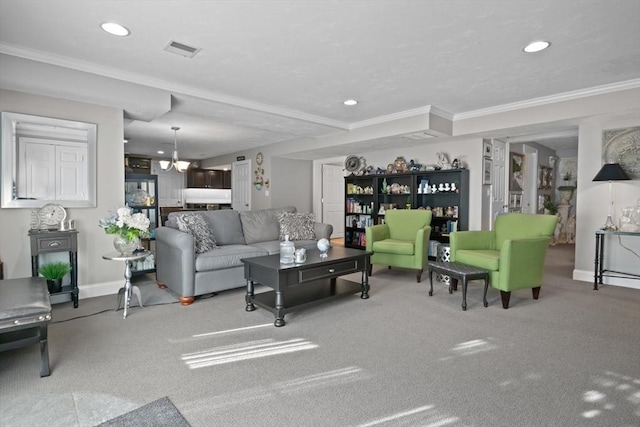 living room featuring crown molding, carpet flooring, and a chandelier