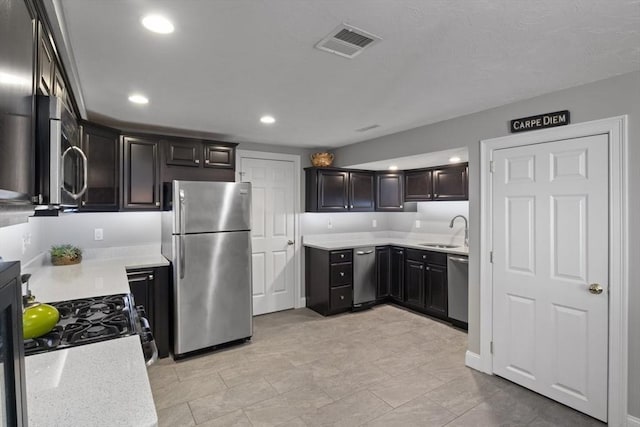 kitchen featuring appliances with stainless steel finishes, sink, and dark brown cabinets