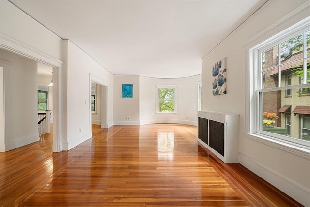 179 Rawson Unit 2, Brookline, MA 02445 - unfurnished living room with light wood-type flooring, a fireplace, radiator heating unit, and baseboards