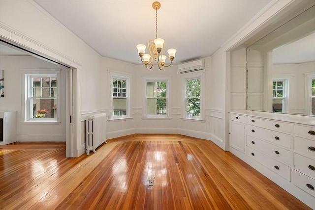 179 Rawson Unit 2, Brookline, MA 02445 - unfurnished dining area with radiator heating unit, a chandelier, an AC wall unit, and light wood-style floors