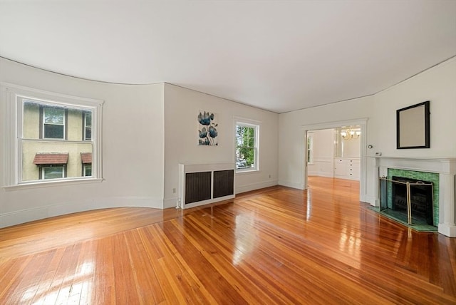 179 Rawson Unit 2, Brookline, MA 02445 - unfurnished living room with a fireplace with flush hearth, baseboards, wood finished floors, and a chandelier