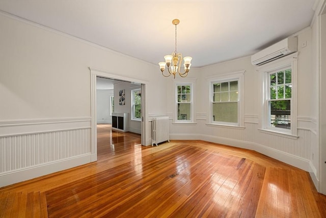 179 Rawson Unit 2, Brookline, MA 02445 - unfurnished dining area featuring radiator heating unit, an AC wall unit, light wood-style floors, a chandelier, and plenty of natural light