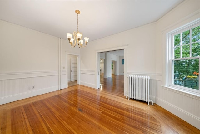 179 Rawson Unit 2, Brookline, MA 02445 - unfurnished room featuring radiator, light wood-type flooring, a chandelier, and ornamental molding