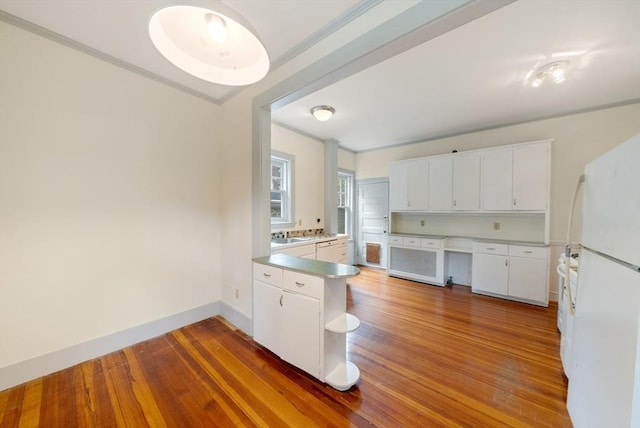 179 Rawson Unit 2, Brookline, MA 02445 - kitchen with freestanding refrigerator, wood finished floors, crown molding, and white cabinets