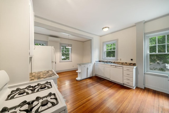 179 Rawson Unit 2, Brookline, MA 02445 - kitchen featuring white appliances, a wall mounted air conditioner, light countertops, white cabinets, and healthy amount of natural light