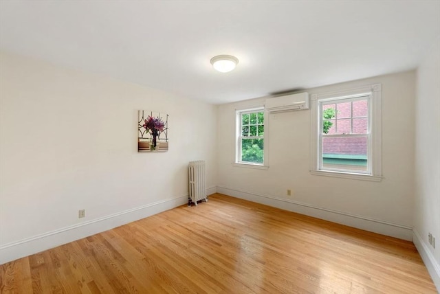 179 Rawson Unit 2, Brookline, MA 02445 - unfurnished room with a wall mounted air conditioner, radiator heating unit, light wood-style floors, and baseboards