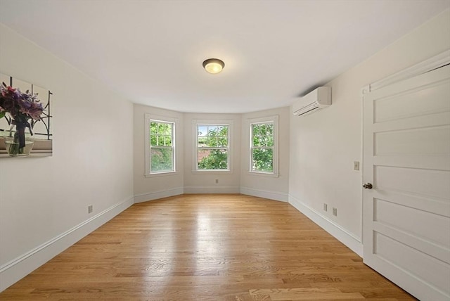 179 Rawson Unit 2, Brookline, MA 02445 - empty room featuring a wall unit AC, light wood finished floors, and baseboards