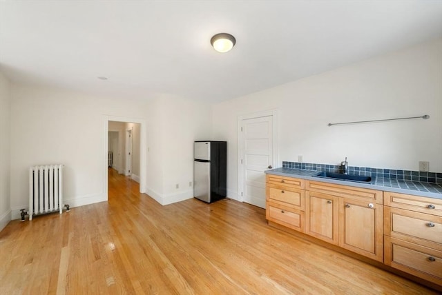 179 Rawson Unit 2, Brookline, MA 02445 - kitchen with radiator, freestanding refrigerator, a sink, light wood-type flooring, and baseboards