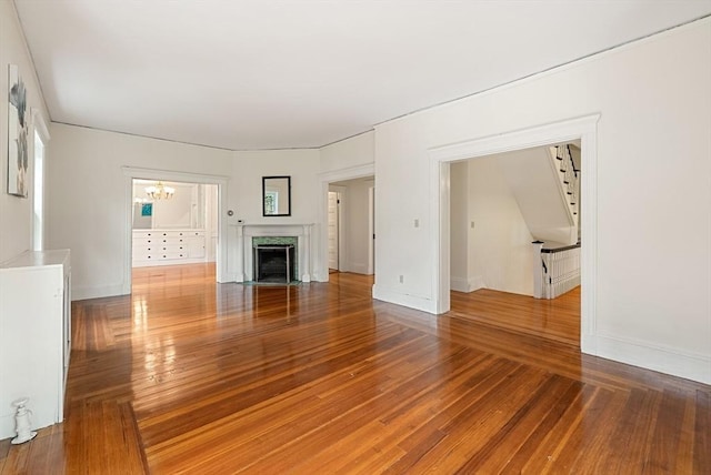 179 Rawson Unit 2, Brookline, MA 02445 - unfurnished living room featuring hardwood / wood-style floors, a chandelier, a premium fireplace, and baseboards