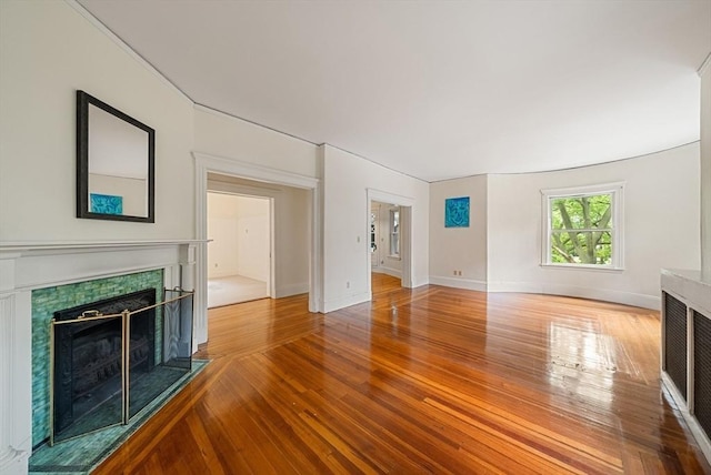 179 Rawson Unit 2, Brookline, MA 02445 - unfurnished living room with a tile fireplace, wood finished floors, and baseboards