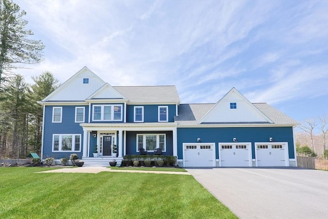 view of front of home featuring covered porch, an attached garage, driveway, and a front yard
