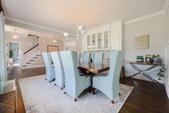 dining room with crown molding, baseboards, stairway, and wood finished floors