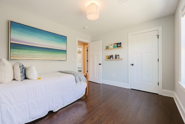 bedroom featuring baseboards and dark wood-type flooring