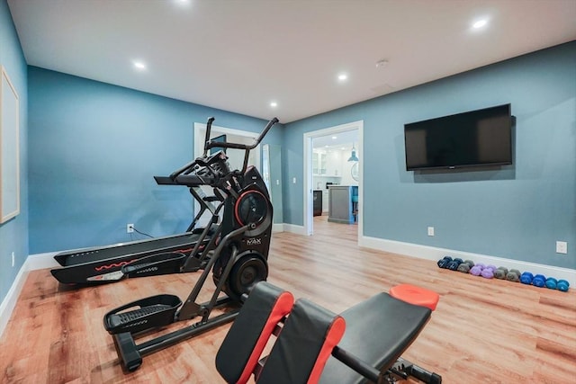 workout area featuring baseboards, recessed lighting, and wood finished floors