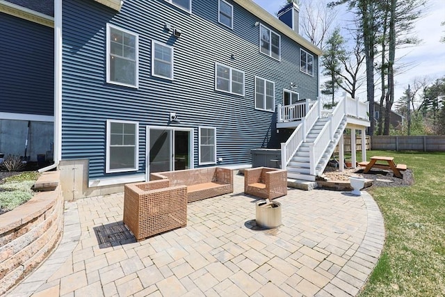 rear view of property featuring a patio, a lawn, fence, and stairway
