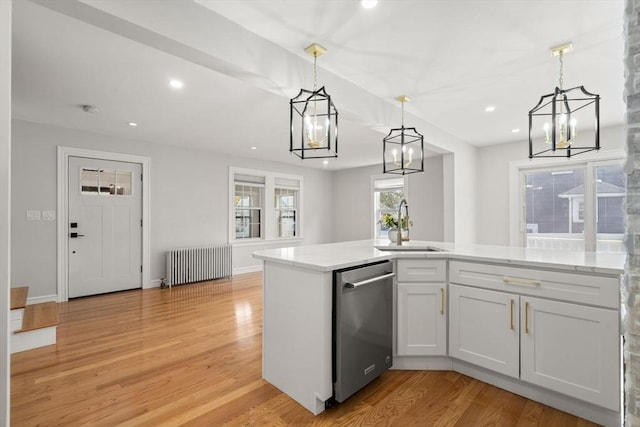 kitchen with a notable chandelier, a sink, radiator heating unit, light wood-type flooring, and stainless steel dishwasher