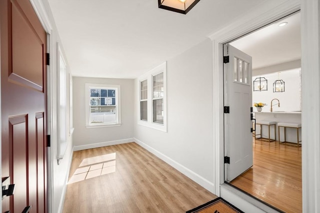 interior space featuring baseboards and light wood finished floors