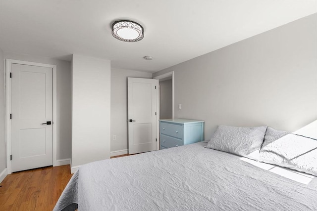 bedroom with baseboards and wood finished floors