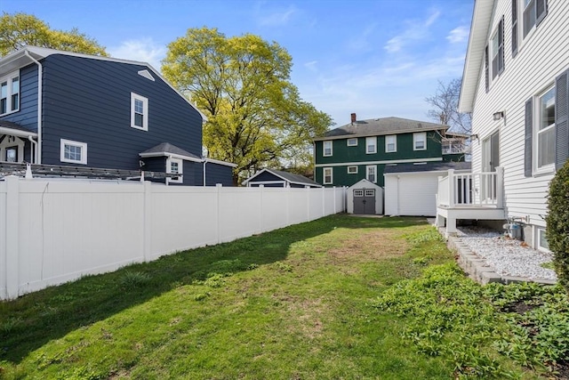 view of yard featuring an outdoor structure, fence, and a shed
