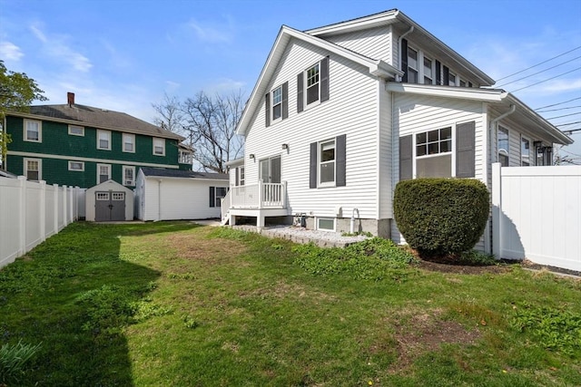back of property featuring fence private yard, an outdoor structure, a shed, and a yard