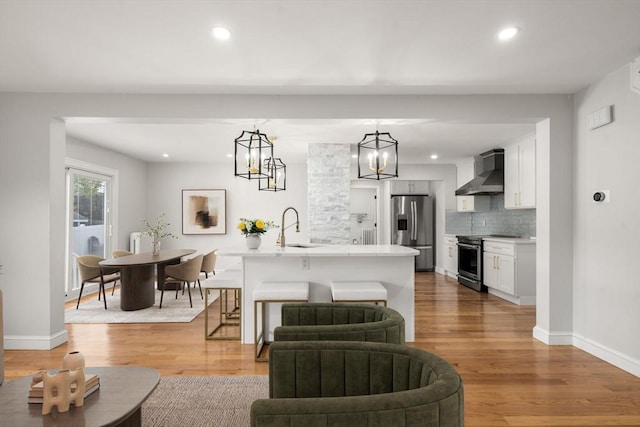 living room with light wood-style floors, baseboards, an inviting chandelier, and recessed lighting