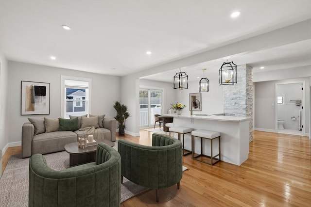 living room featuring recessed lighting, light wood-style flooring, and a healthy amount of sunlight