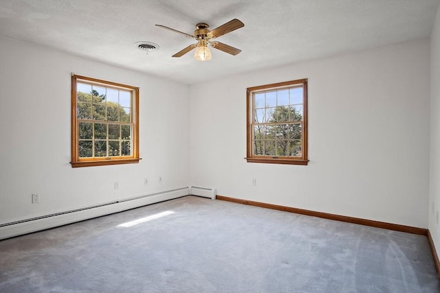 carpeted empty room featuring a ceiling fan, visible vents, baseboards, and baseboard heating